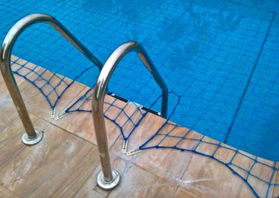 Pool safety net fitted around steps.
